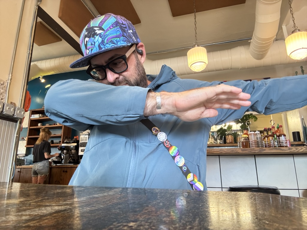 Off_The_Radar_MP4.zip 3 Tukayote in a patterned cap and sunglasses dabbing at a cafe counter