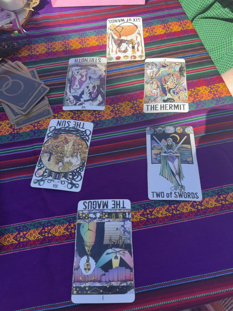Living_On_Purpose_v1.zip 2 Tarot spread on a striped purple cloth, including The Hermit, Two of Swords, and The Magus